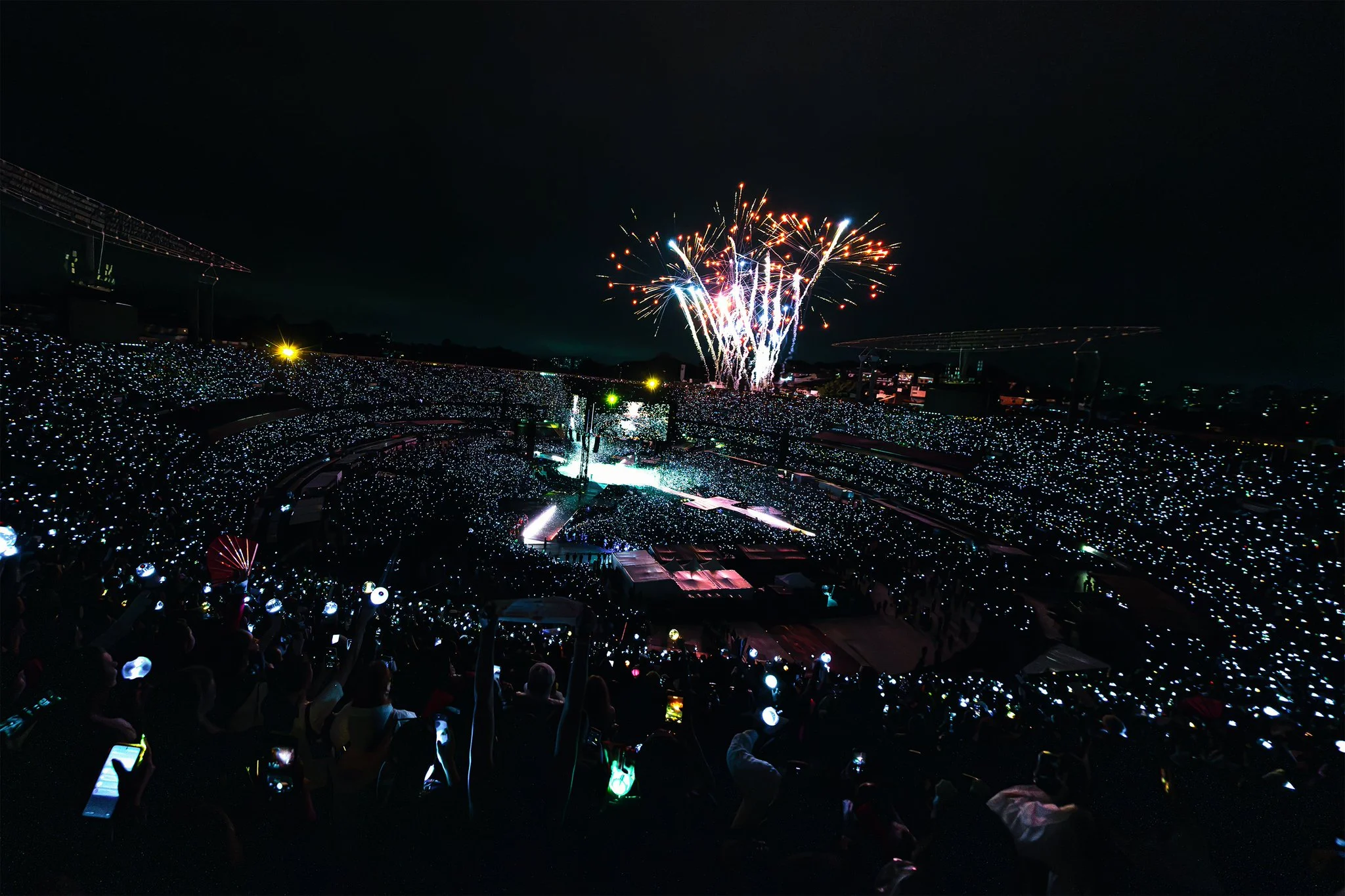 Fogos de artifício sobre o MorumBIS lotado e iluminado por ARMY Bombs na segunda noite do BTS