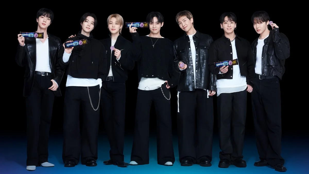 Os sete integrantes do BTS segurando pacotes de OREO BTS sabor hotteok
