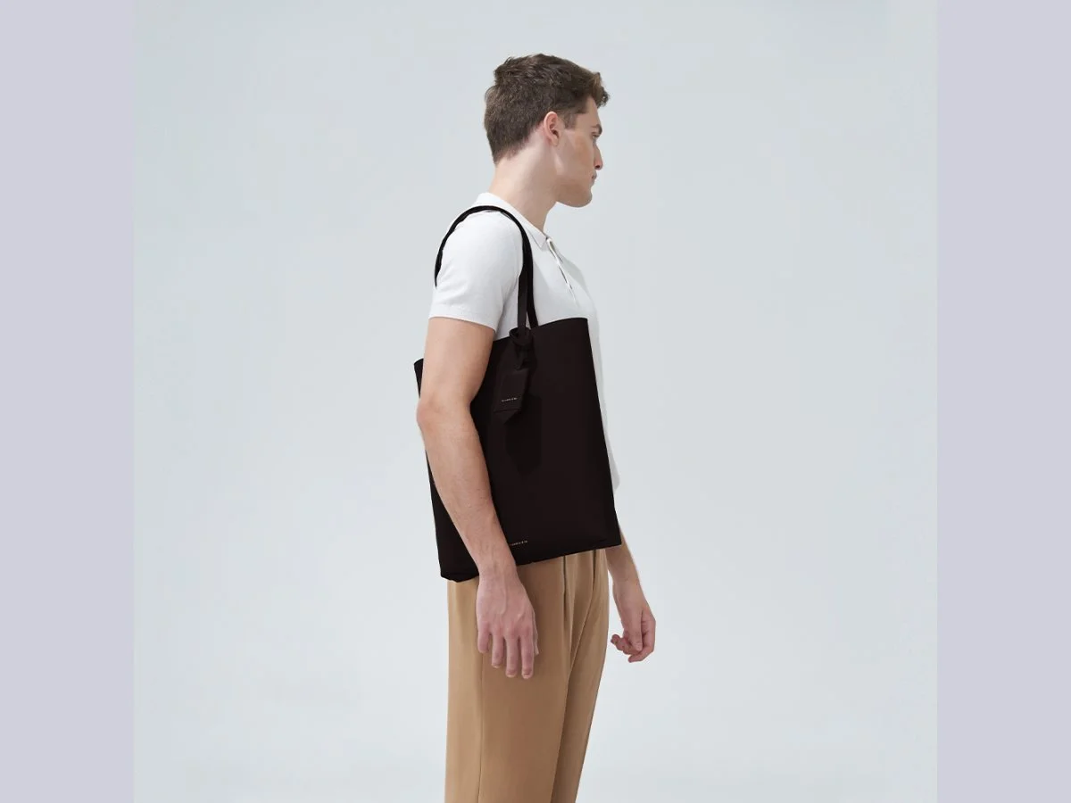 Modelo usa a bolsa Grand Noah em couro preto da Escudero
