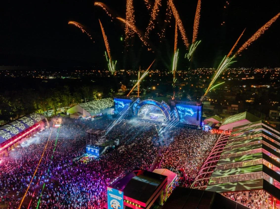 Vista aérea do Planeta Atlântida à noite com fogos de artifício sobre o palco e o público lotado